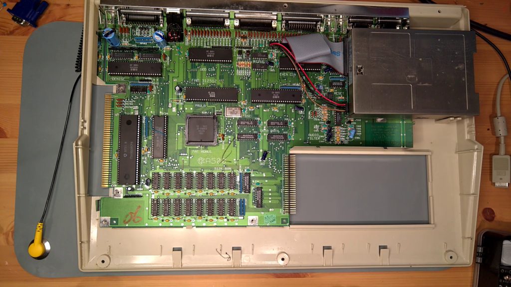 Commodore Amiga 500 with the top case and keyboard off, showing a motherboard with two black resistors on top
