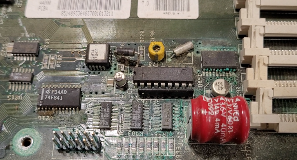 View of the clock portion of a Commodore Amiga 4000 motherboard separated from the case, covered in a blue-green hue due to the damage from battery leakage